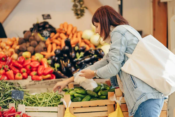 若い女性は 食品市場で綿の生産袋に果物や野菜を置きます 買い物に再利用可能なエコバッグ 持続可能なライフスタイル 環境にやさしいコンセプト — ストック写真