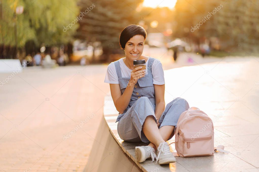 Young woman with reusable coffee cup at sunset. Sustainable lifestyle. Plastic free concept.