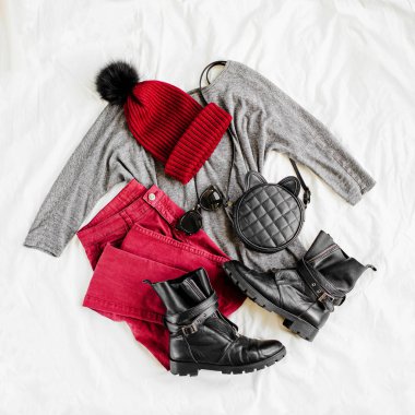 Vinous kış şapka ve gri kazak, çanta ve beyaz levha üzerinde çizme ile pantolon. Kadın şık sonbahar veya kış kıyafeti. Modaya uygun giysi kolajı. Düz döşeme, üst görünüm. 