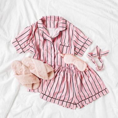 Kabarık kürk terlik ile Pijama uyku seti. Yatakta çizgili klasik pembe uyku elbisesi. Günaydın konsepti. Düz döşeme, üst görünüm