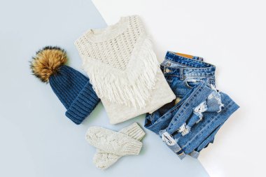 Kot pantolon, kazak ve beyaz arka plan üzerinde eldiven ile Mavi kış şapka. Kadın şık sonbahar veya kış lık giysiler. Modaya uygun giysi kolajı. Düz döşeme, üst görünüm.