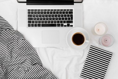 Laptop ve kahveyle yatakta çalışma alanı. Sabah konsepti. Düz yatıyordu 