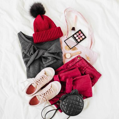 Vinous kış şapka ve gri kazak, çanta ve beyaz levha üzerinde spor ayakkabı ile pantolon. Kadın şık sonbahar veya kış kıyafeti. Modaya uygun giysi kolajı. Düz döşeme, üst görünüm. 