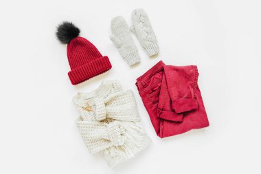 Gri sıcak örme kazak, beyaz arka plan üzerinde vinous kış şapka ve pantolon ile eldiven. Kadın şık sonbahar veya kış lık giysiler. Düz döşeme, üst görünüm.