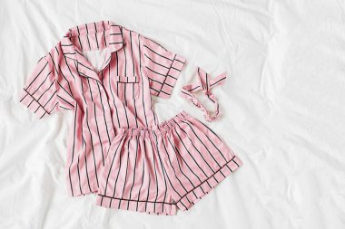 Pijama uyku seti. Yatakta çizgili klasik pembe uyku elbisesi. Günaydın konsepti. Düz döşeme, üst görünüm