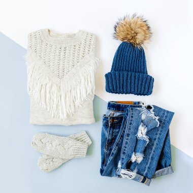 Kot pantolon, kazak ve beyaz arka plan üzerinde eldiven ile Mavi kış şapka. Kadın şık sonbahar veya kış lık giysiler. Modaya uygun giysi kolajı. Düz döşeme, üst görünüm.