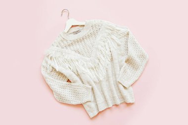 Soluk pembe arka plan üzerinde gri sıcak örme kazak. Kadın şık sonbahar veya kış lık giysiler. Düz döşeme, üst görünüm.
