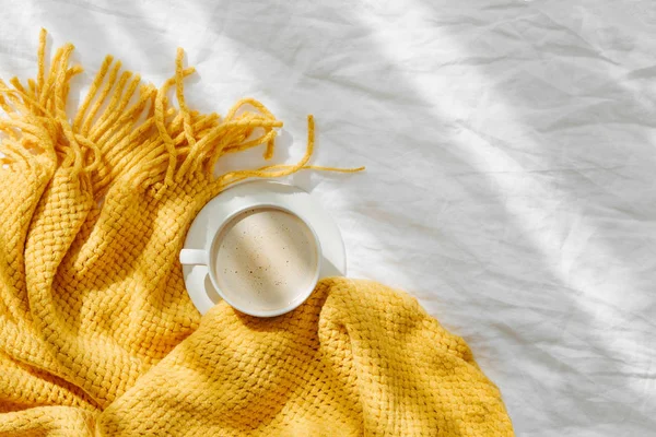带黄色针织格子和咖啡的床上用品 舒适的背景和复制空间 海格概念 — 图库照片