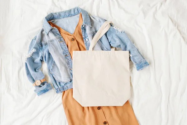 Blauwe Jean Jas Beige Jurk Met Tote Tas Wit Bed — Stockfoto