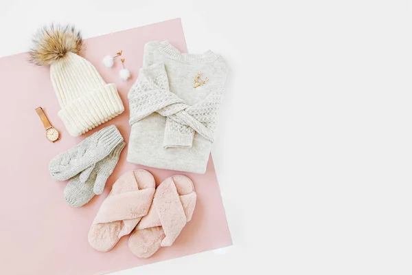 灰色温暖的针织毛衣 冬季帽子 手套和蓬松的毛皮拖鞋在淡粉色的背景 女装时尚冬装 顶视图 — 图库照片