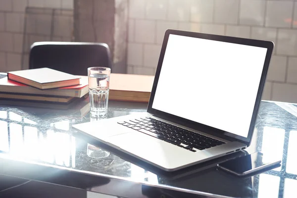 Closeup view of opened laptop screen, space for design layout. Co-working open space loft, mobile smartphone, metallic cold interior.