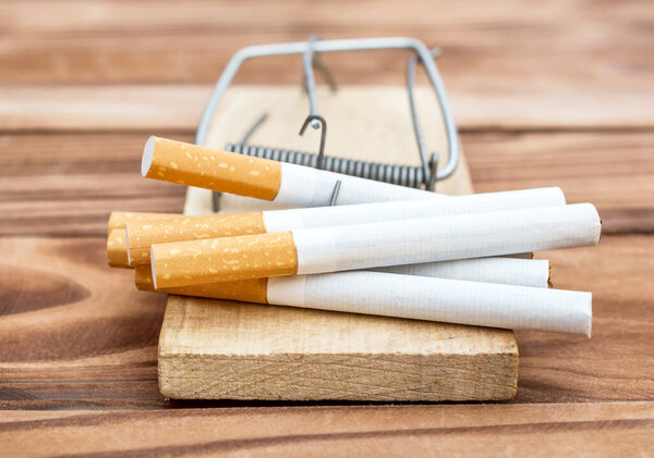 Ловушка с сигаретами на деревянном столе. Закрыть
.