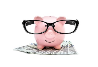 Beyaz arka planda parası olan gözlüklü domuz kumbarası..