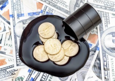 Dolar banknotlarının arka planına dökülen ham petroldeki madeni paralar. İş konsepti. Üst görünüm.