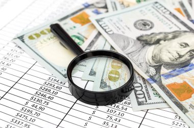 Finansal belgelerde dolar banknotları olan büyüteç. İş konsepti.