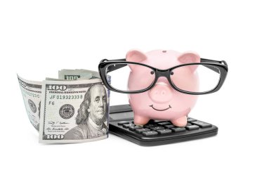 Gözlüklü domuz kumbarası, hesap makinesi ve beyaz banknotlar. İş konsepti.