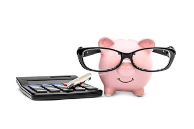 Gözlüklü domuz kumbarası, hesap makinesi ve beyaz arka planda kalem..