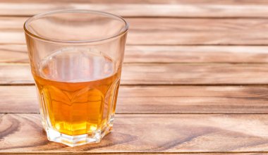 Ahşap arka planda bir bardak viski. Metin için boşluk.