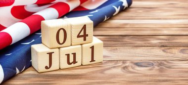 Tahta küplerde 4 Temmuz tarihi ve tahta arka planda Amerikan bayrağı. ABD 'nin bağımsızlık günü. Metin için boşluk.