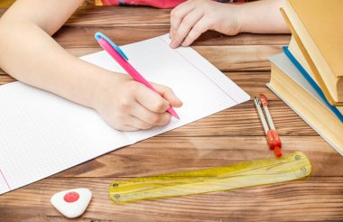 Çocuk ödevini masada yapıyor..