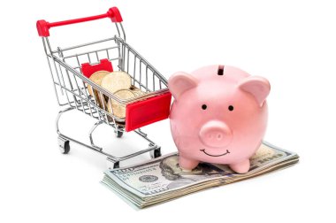 Alışveriş arabası ve beyaza para yatırılmış domuz kumbarası. Tasarruf kavramı.