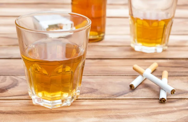 ウイスキーのグラスにタバコとウイスキーのボトルが木製の背景に 閉じろ — ストック写真
