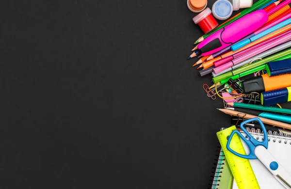 Okul malzemelerinin çerçevesi siyah arka planda. Üst Manzara. Metin için boşluk.