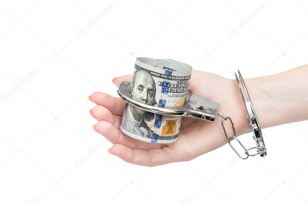 Woman's hand holding money which chained by handcuffs to hand. Isolated on white.