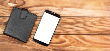 Boş ekranlı akıllı telefon ve ahşap masada cüzdan. Üst Manzara. Metin için boşluk.