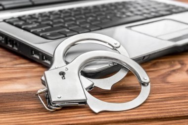 Elleri kelepçeli operasyon masasında. Siber suç kavramı. 