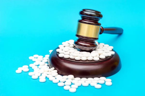 Gavel mavi üzerine beyaz haplar. Tıbbi konsept.