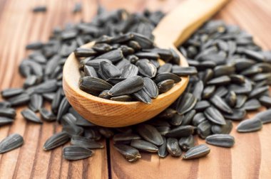 Tahta masada ayçiçeği tohumlu tahta kaşık. Kapat..