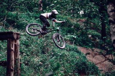 Rusya, Moskova - 26 Ağustos 2020: MTB ile çakıl üzerinden atlayan profesyonel bisikletçi. Doğada bisiklete binen biri. Bisikletli havalı bir sporcu. MTB bisikleti.