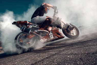 Moskova, Rusya - 13 Temmuz 2020: Moto binicisi motosikletini yakıyor. Motosikletli patinaj çekiyor. Motosikletli tehlikeli bir dublör..