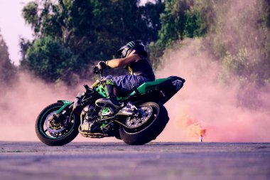 Moskova, Rusya - 12 Temmuz 2020: Moto binicisi motosikletini kullanıyor. Motosiklet dublörü motosiklet gösterisi yapıyor. Motosikletli, motorsikletinin üzerinde zor ve tehlikeli bir gösteri yapıyor.