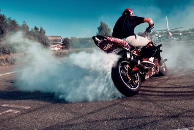 Moskova, Rusya - 13 Temmuz 2020: Moto binicisi motosikletini yakıyor. Motosiklet dublörü motosiklet gösterisi yapıyor. Motosikletli tehlikeli bir gösteri yapıyor.