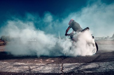 Moskova, Rusya - 13 Temmuz 2020: Moto binicisi motosikletini yakıyor. Motosiklet dublörü motosiklet gösterisi yapıyor. Motosikletli tehlikeli bir gösteri yapıyor.