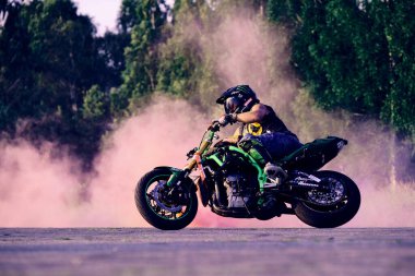 Moskova, Rusya - 12 Temmuz 2020: Moto binicisi motosikletini kullanıyor. Motosiklet dublörü motosiklet gösterisi yapıyor. Motosikletli, motorsikletinin üzerinde zor ve tehlikeli bir gösteri yapıyor.