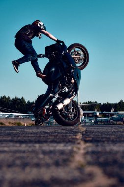 Moskova, Rusya - 12 Temmuz 2020: Moto binicisi motosikletini kullanıyor. Motosiklet dublörü motosiklet gösterisi yapıyor. Motosikletli, motorsikletinin üzerinde zor ve tehlikeli bir gösteri yapıyor.