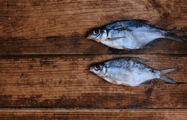 Koyu ahşap arka planda tuzlu, kuru nehir balığı. Pazarda kurutulmuş balık. Sokak yemeği..