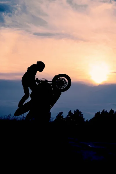 日落时骑摩托车的人的轮廓 摩托骑手骑摩托车作特技表演 — 图库照片