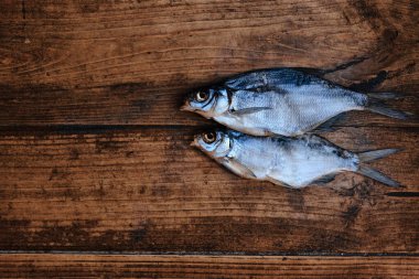 Koyu ahşap arka planda tuzlu, kuru nehir balığı. Pazarda kurutulmuş balık. Sokak yemeği. Metin için alanı olan resim.