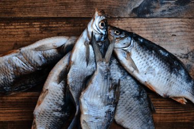 Koyu ahşap arka planda tuzlu, kuru nehir balığı. Pazarda kurutulmuş balık. Sokak yemeği..