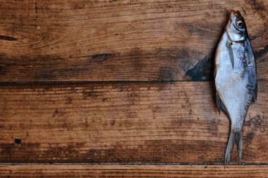 Koyu ahşap arka planda tuzlu, kuru nehir balığı. Pazarda kurutulmuş balık. Sokak yemeği..