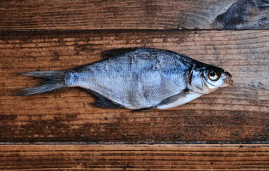 Koyu ahşap arka planda tuzlu, kuru nehir balığı. Pazarda kurutulmuş balık. Sokak yemeği..