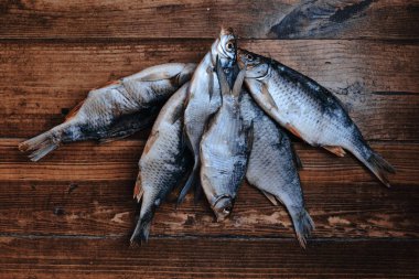 Koyu ahşap arka planda tuzlu, kuru nehir balığı. Pazarda kurutulmuş balık. Sokak yemeği..