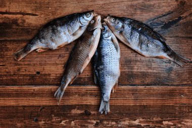 Koyu ahşap arka planda tuzlu, kuru nehir balığı. Pazarda kurutulmuş balık. Sokak yemeği..