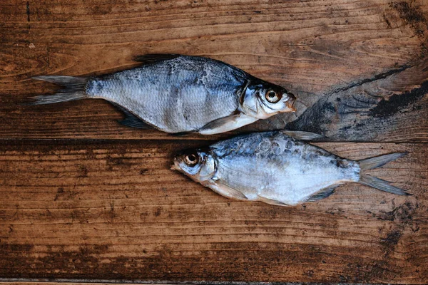 Koyu ahşap arka planda tuzlu, kuru nehir balığı. Pazarda kurutulmuş balık. Sokak yemeği..