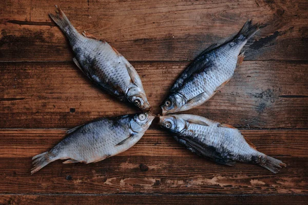 Koyu ahşap arka planda tuzlu, kuru nehir balığı. Pazarda kurutulmuş balık. Sokak yemeği..