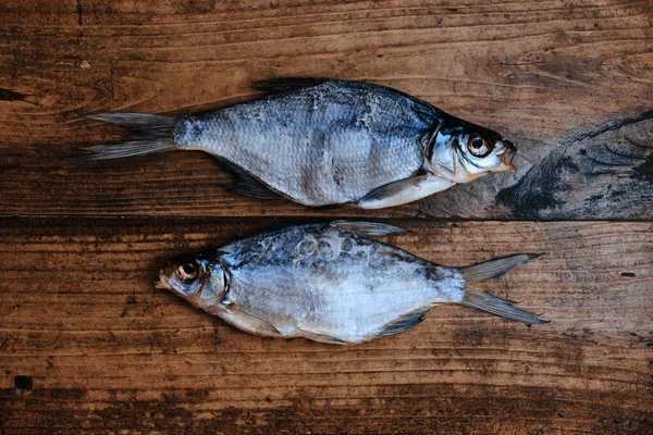 Salty dry river fish on a dark wooden background. Dry fish in the market. Street food.